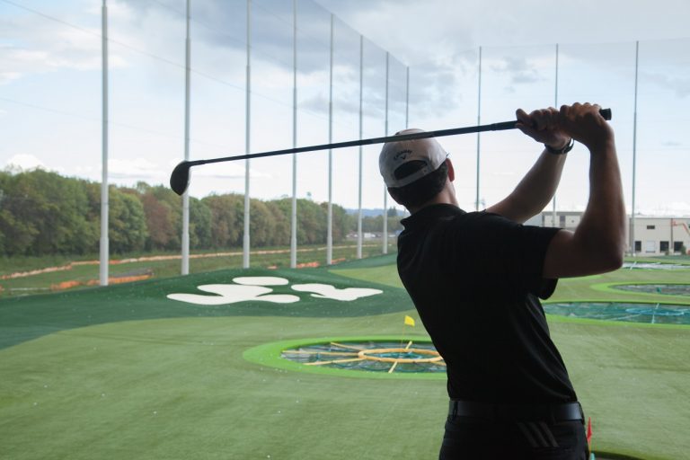 Golfer taking a swing at Topgolf in Tualatin Valley