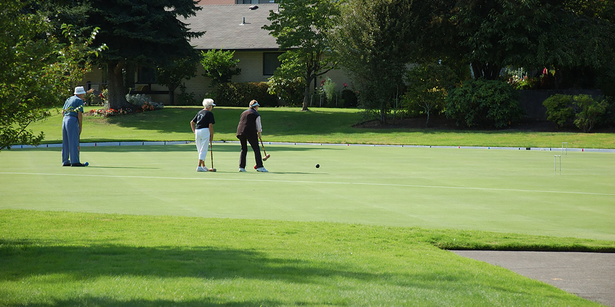 three people playing croquet