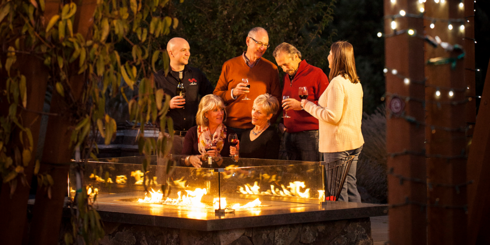 friends enjoying wine near a firepit