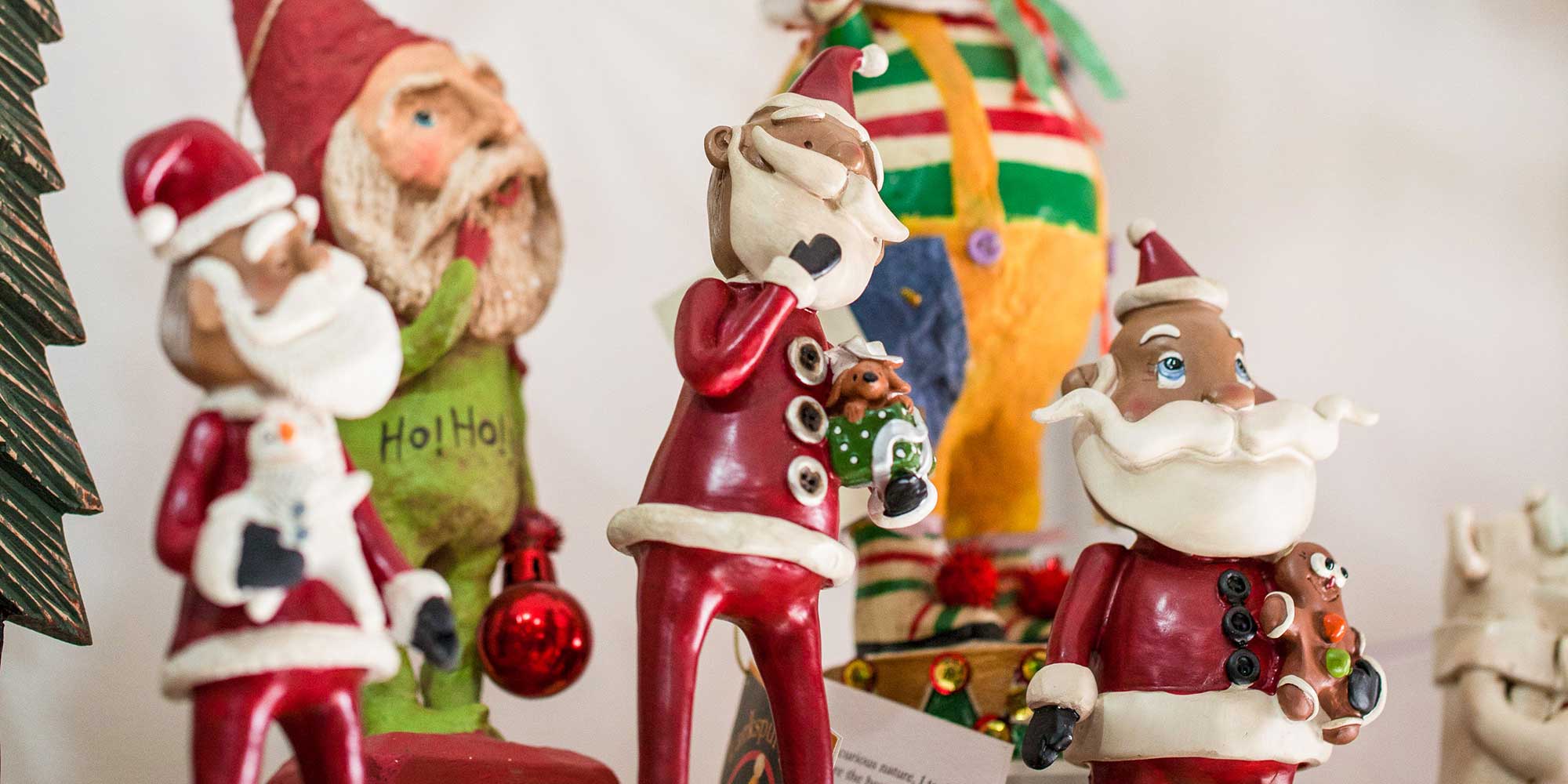 multiple hand crafted santas on a shelf