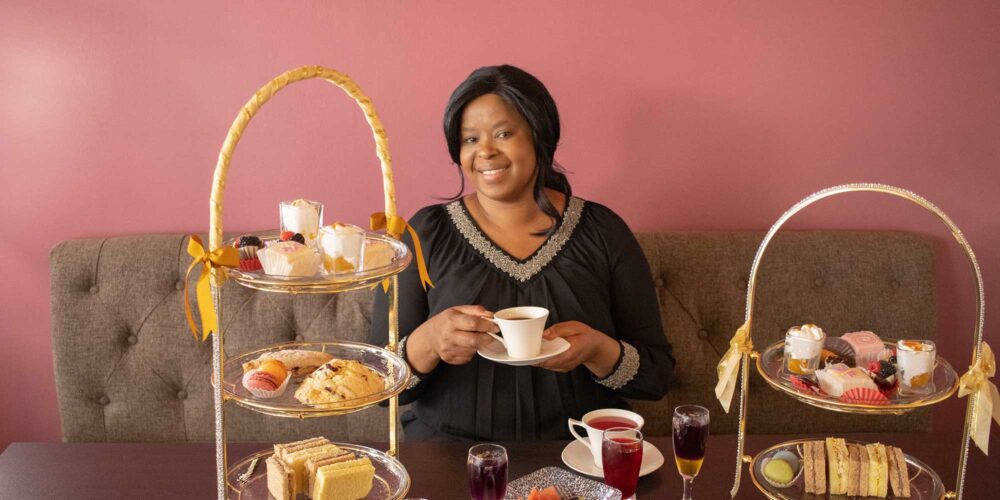 woman sitting at a table with desserts and coffee