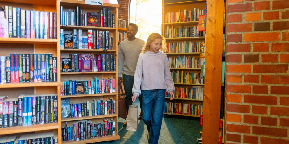 father and daughter shopping for books in a bookstore