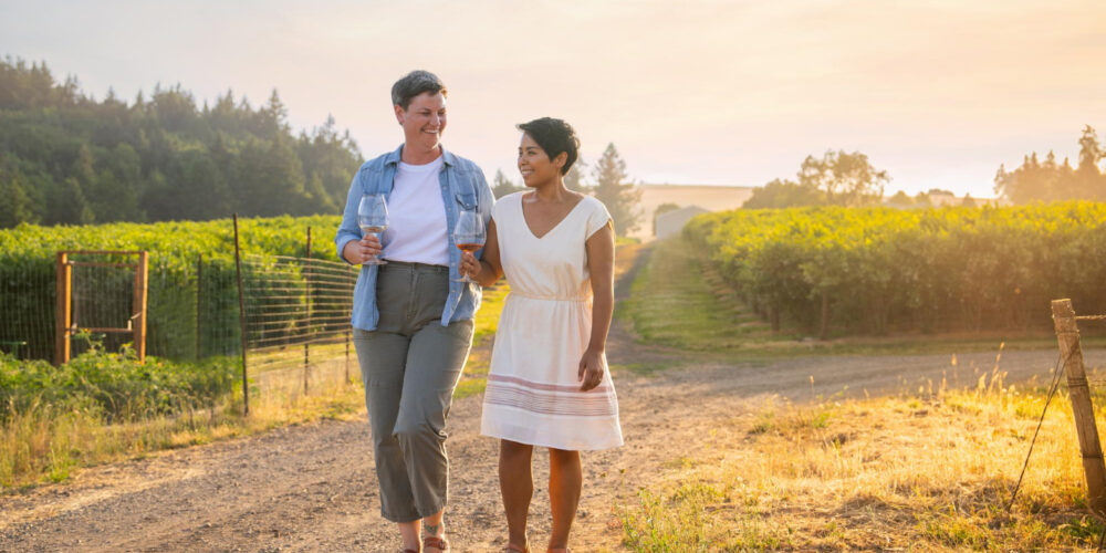 two women walking through a vineyard