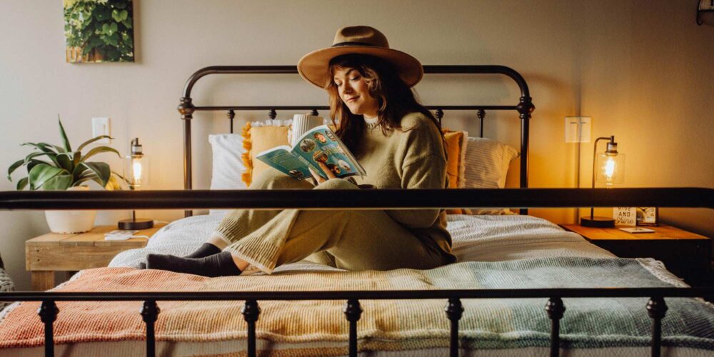 woman reading a book on a bed