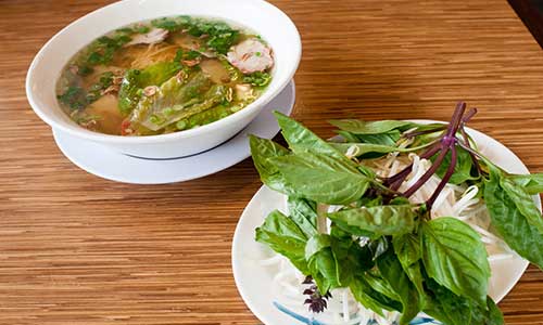 bowl of pho and salad