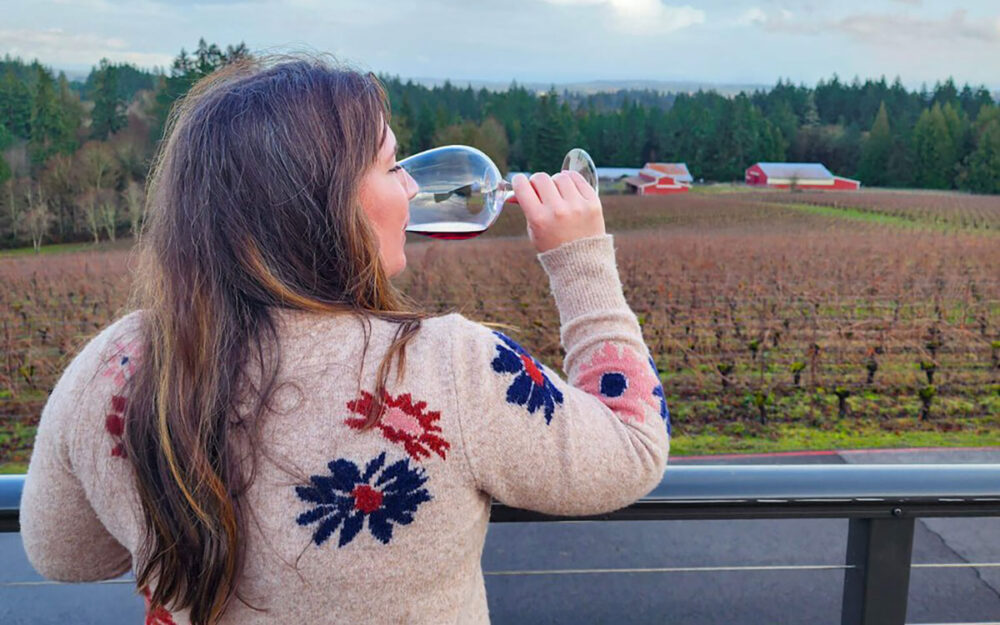 woman drinking a glass of wine outside in a vinyard