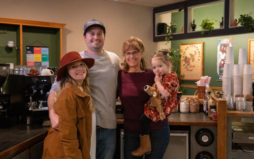 picture of a family posing behind a coffee counter