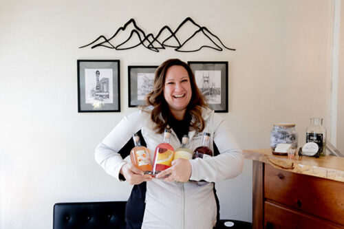 Urban River Spirits - Michelle Garner image of woman holding bottles of bourbon